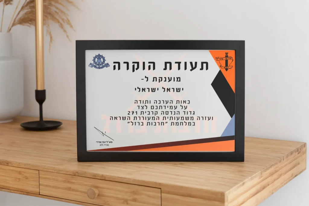 תעודת הוקרה ממוסגרת מונחת על שידת עץ לצד מנורה