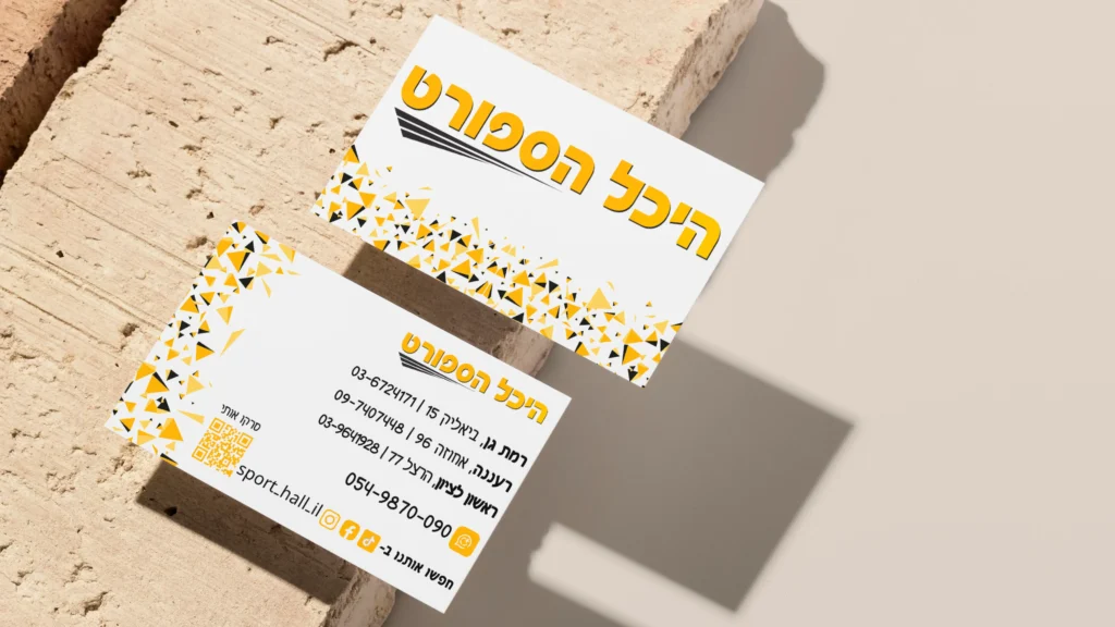 שני כרטיסי ביקור של היכל הספורט בגווני לבן וצהוב על משטח אבן